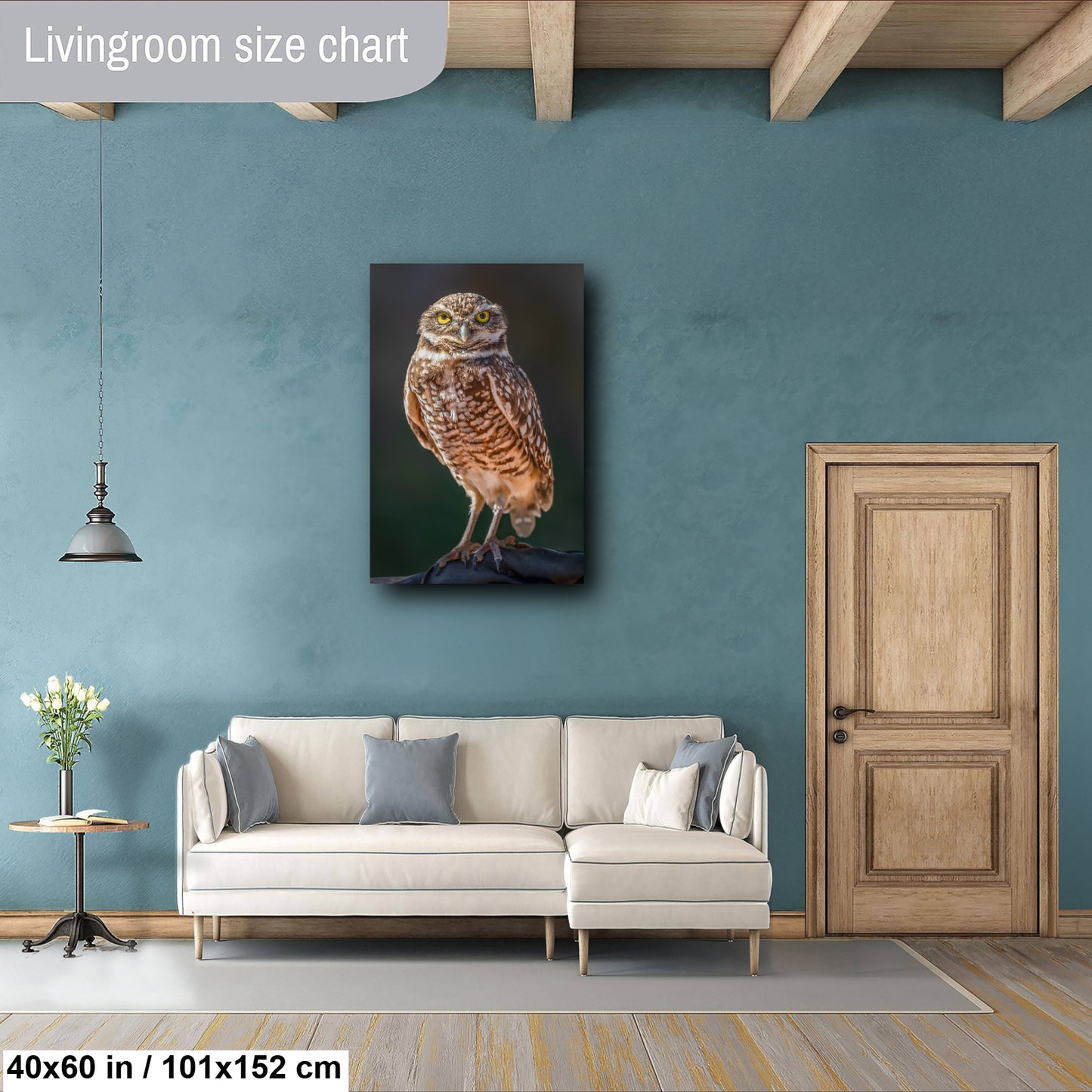 a living room with a large painting of a bird, specifically an owl, hanging on the wall. The room has a white sofa and a wooden door, creating a cozy and inviting atmosphere.