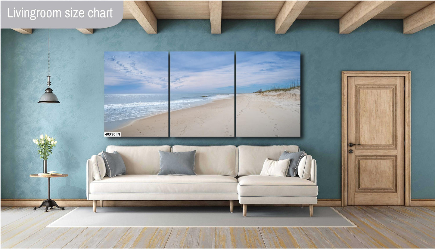 A wall art print featuring a beach scene with footprints on the sand, the ocean, and a clear sky.