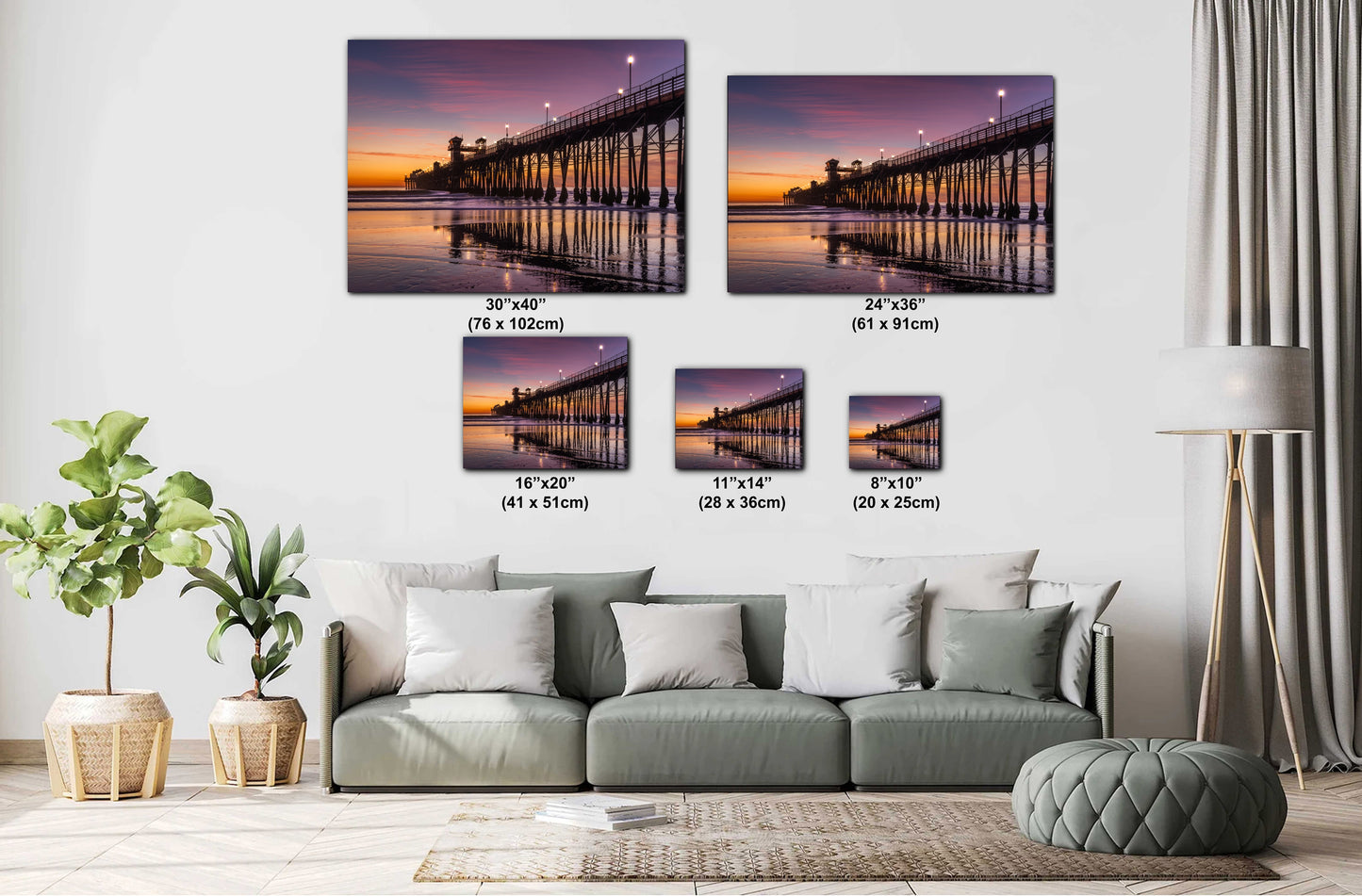 a living room with a gray sofa and a potted plant. Above the sofa, there are four framed pictures of a pier at sunset, each with a different size and resolution. The pictures are arranged in a grid-like pattern on the wall, creating a visually appealing display.