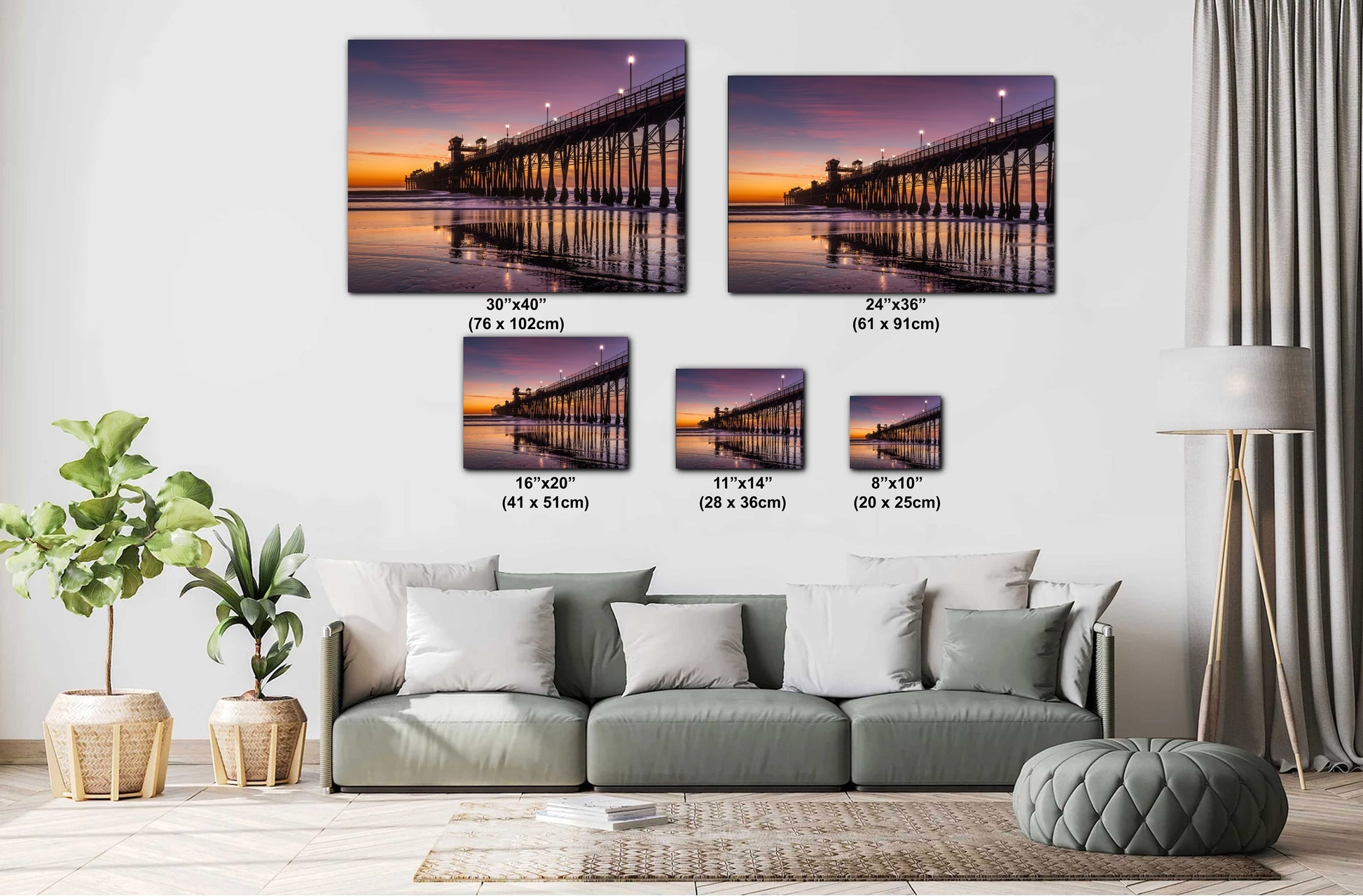 a living room with a gray sofa and a potted plant. Above the sofa, there are four framed pictures of a pier at sunset, each with a different size and resolution. The pictures are arranged in a grid-like pattern on the wall, creating a visually appealing display.