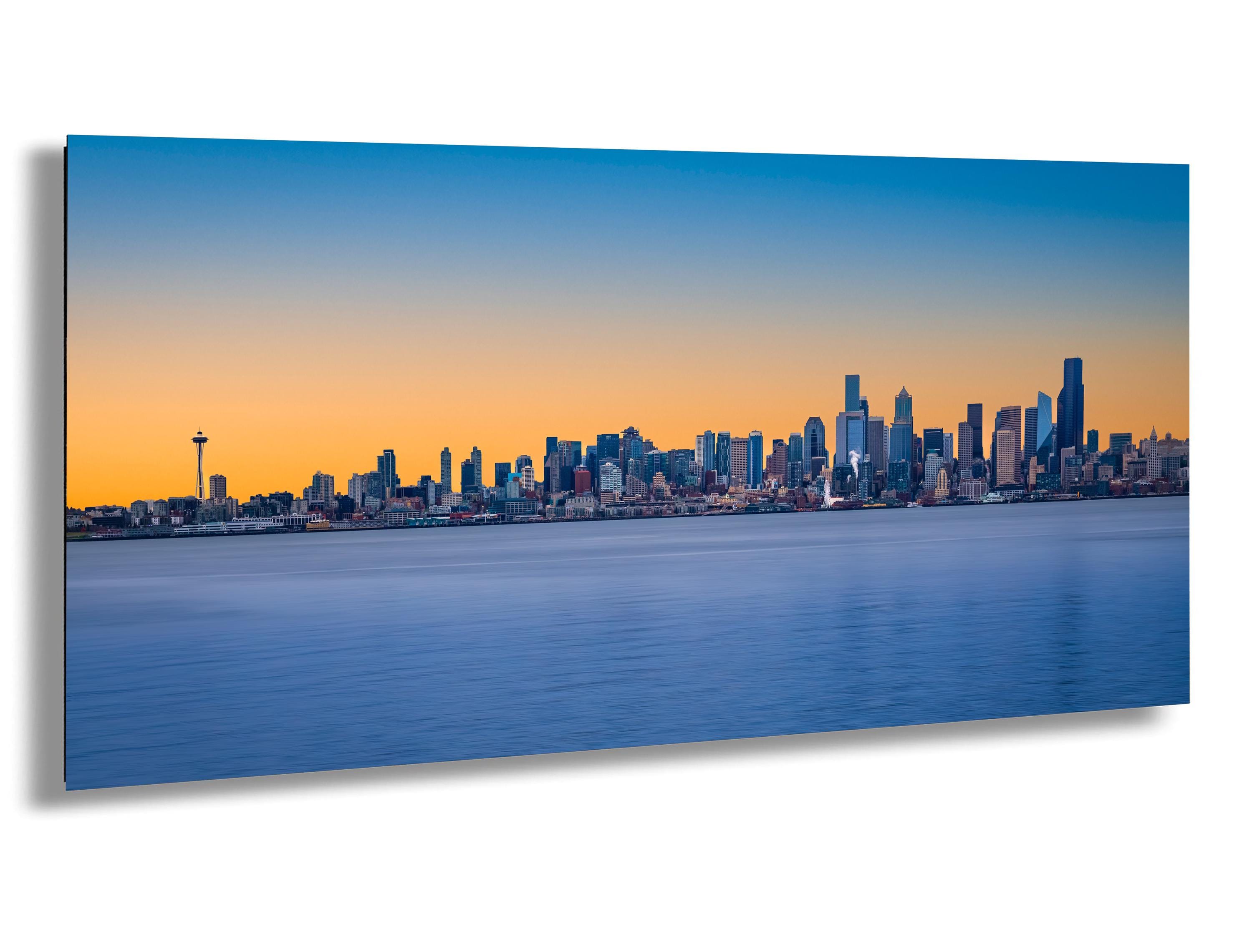 Seattle skyline at sunrise over Elliott Bay with Space Needle, smooth blue water