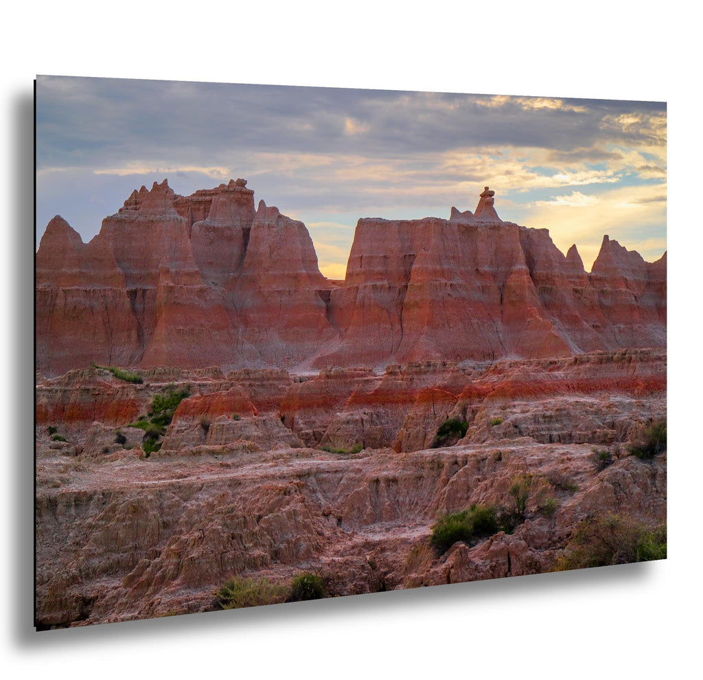 Badlands National Park red rock citadel formations at sunset with glowing sky.