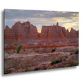 Badlands National Park red rock citadel formations at sunset with glowing sky.