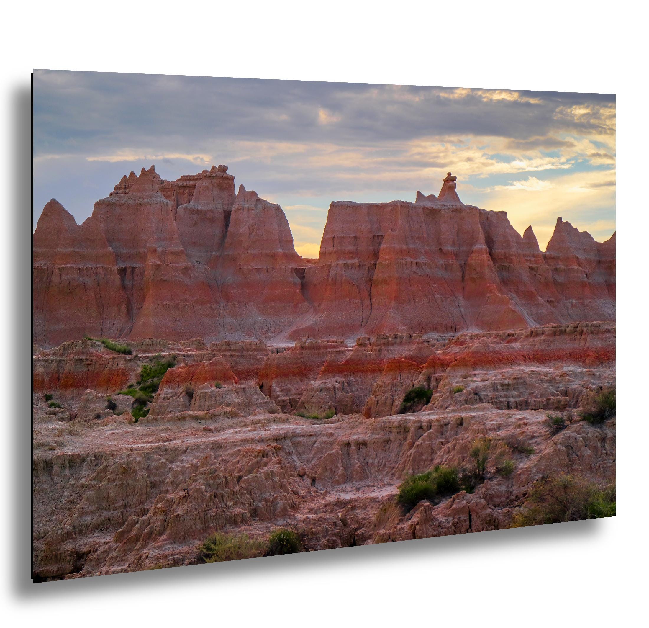 Badlands National Park red rock citadel formations at sunset with glowing sky.