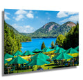 Outdoor setting with green umbrellas and tables by a lake with mountains in the background at Jordan Pond House,  Acadia National Park