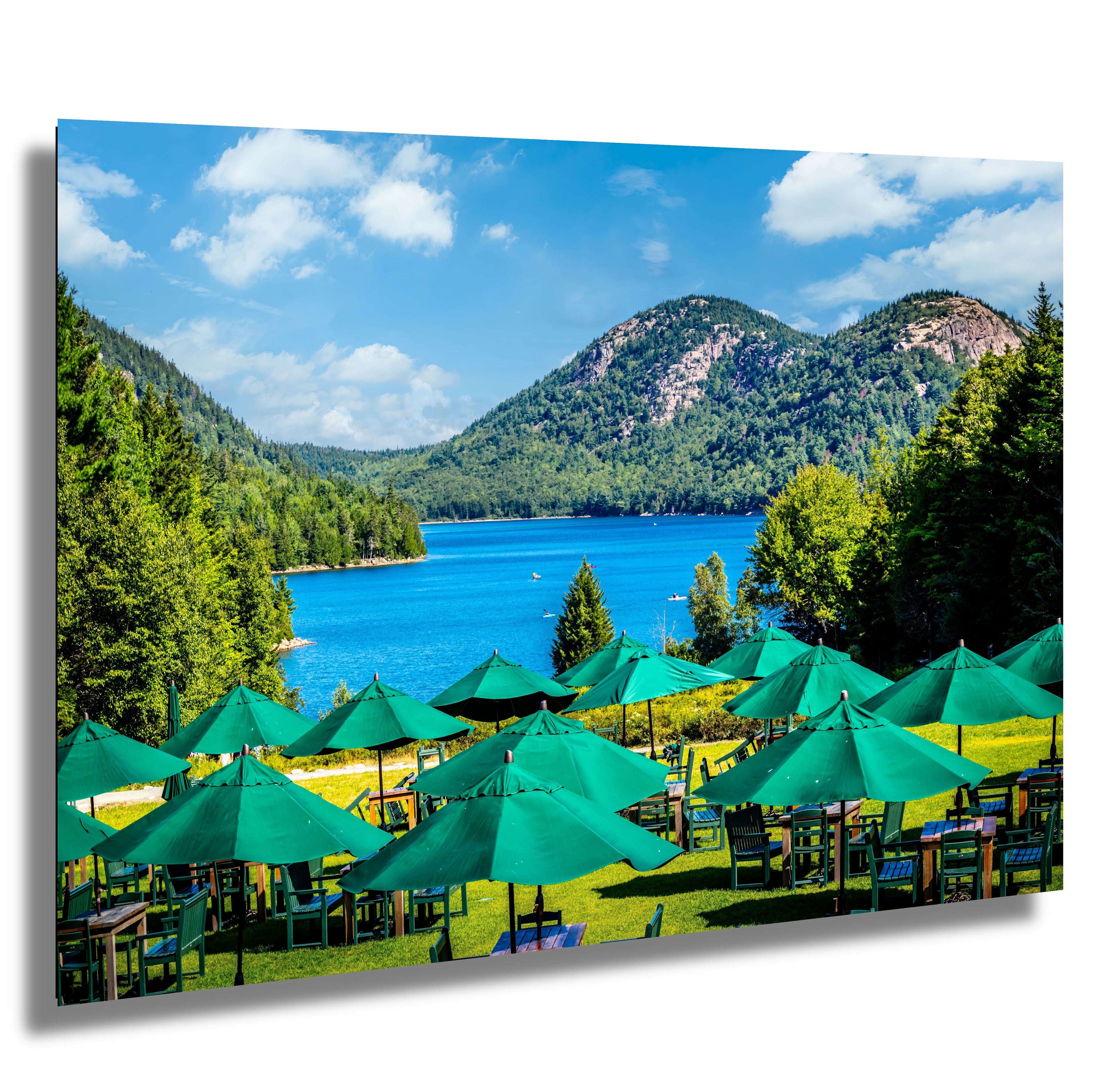 Outdoor setting with green umbrellas and tables by a lake with mountains in the background at Jordan Pond House,  Acadia National Park
