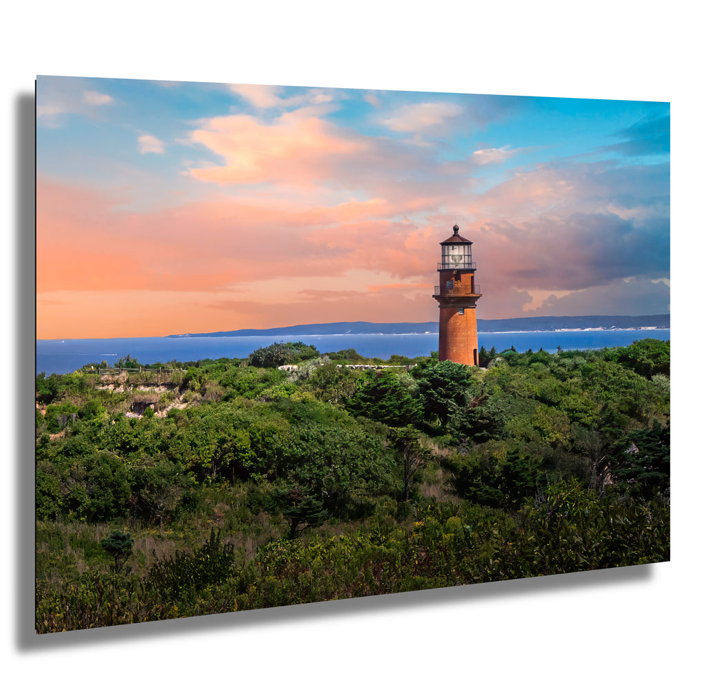 Lighthouse on a hill with a colorful sky and ocean at Martha's Vineyard