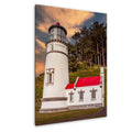 Heceta Head Lighthouse with a red roof and surrounding trees against a sunset sky