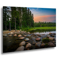 Mississippi River headwaters at Itasca State Park with rocks, forest, and sunset sky