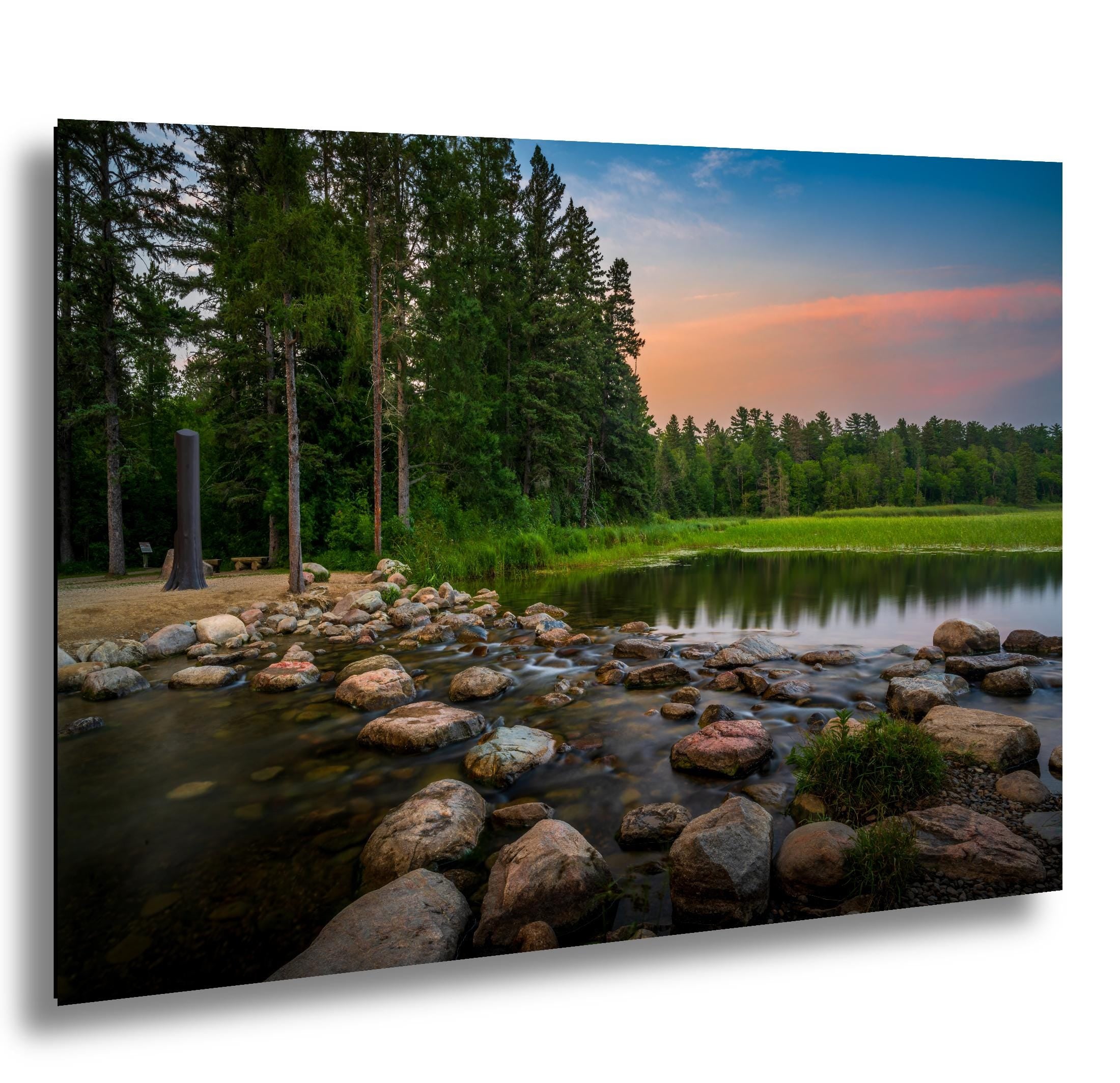 Mississippi River headwaters at Itasca State Park with rocks, forest, and sunset sky
