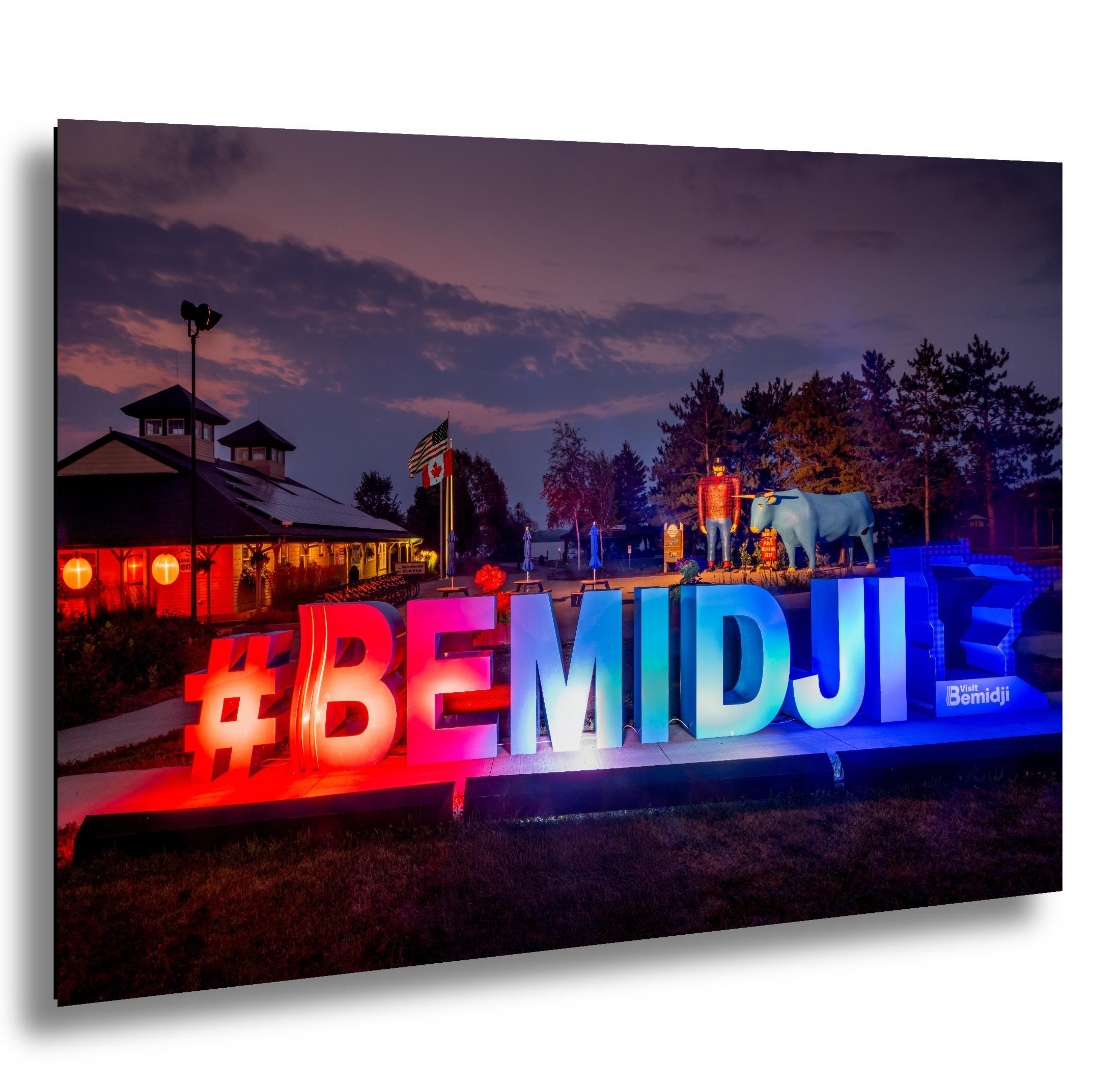 Colorful outdoor setting with '#BEMIDJI' sign and festive decorations at dusk.