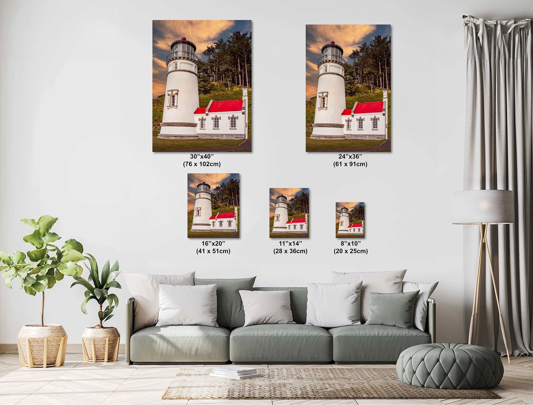 Living room with a gray sofa and decorative plants, featuring framed pictures of Heceta Head Lighthouse.