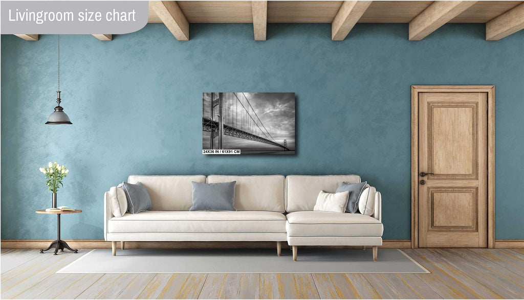 A black and white photograph of the Mackinac Bridge, capturing the engineering and grandeur of the structure with a backdrop of overcast sky and a body of water.