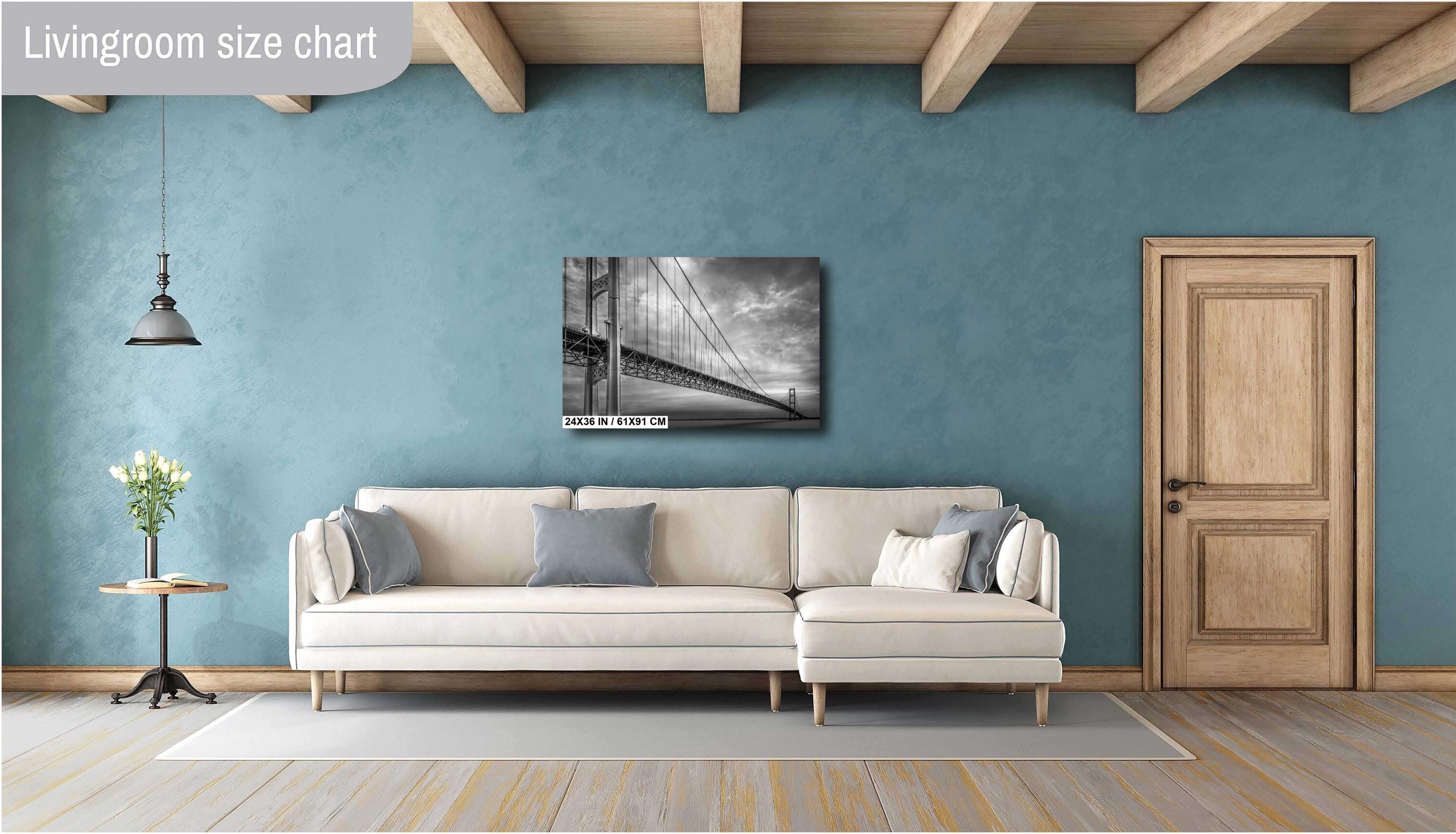 A black and white photograph of the Mackinac Bridge, capturing the engineering and grandeur of the structure with a backdrop of overcast sky and a body of water.