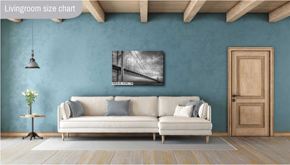 A black and white photograph of the Mackinac Bridge, capturing the engineering and grandeur of the structure with a backdrop of overcast sky and a body of water.