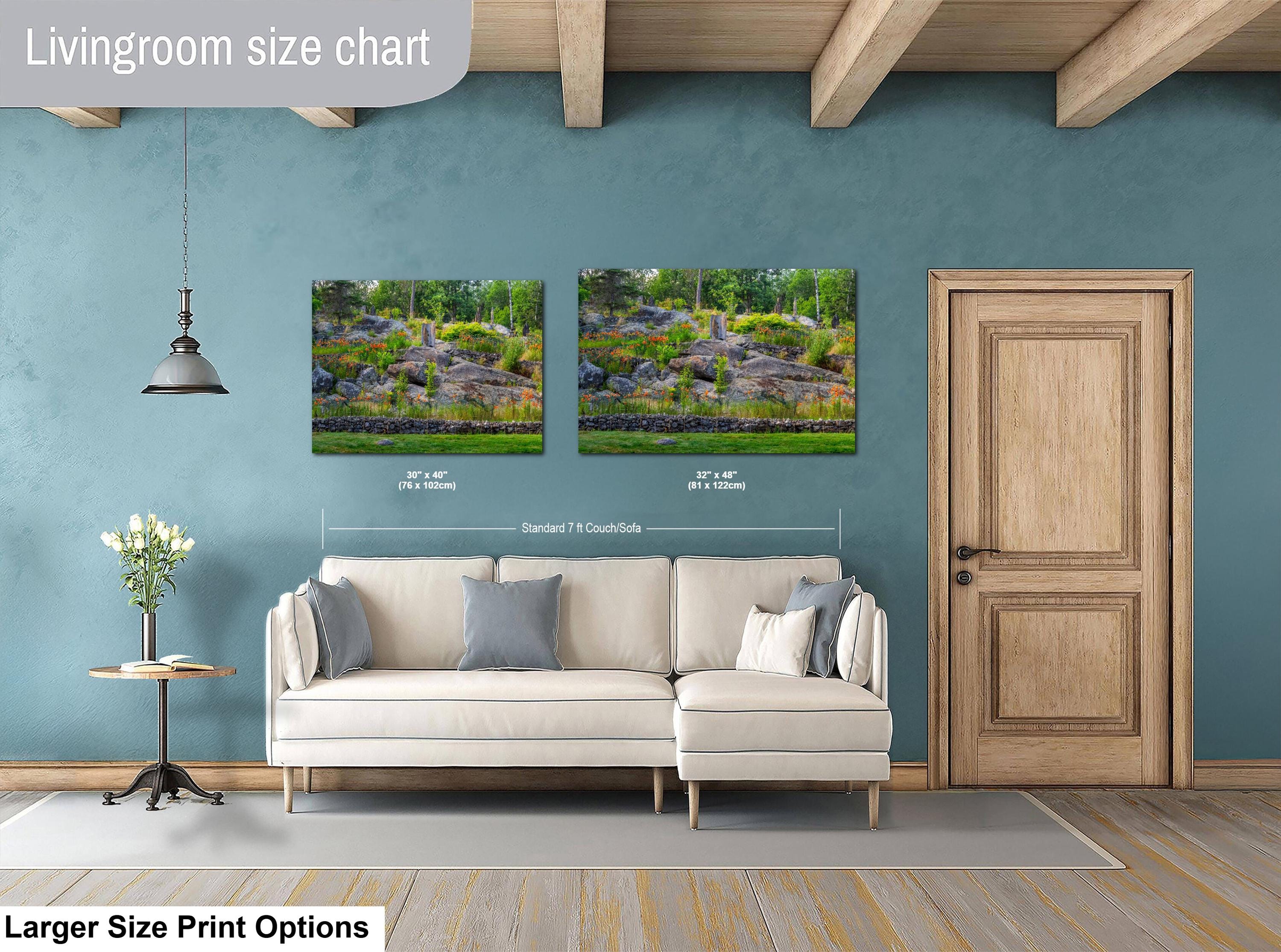 Living room with a beige sofa, side table, and two landscape prints on a blue wall.