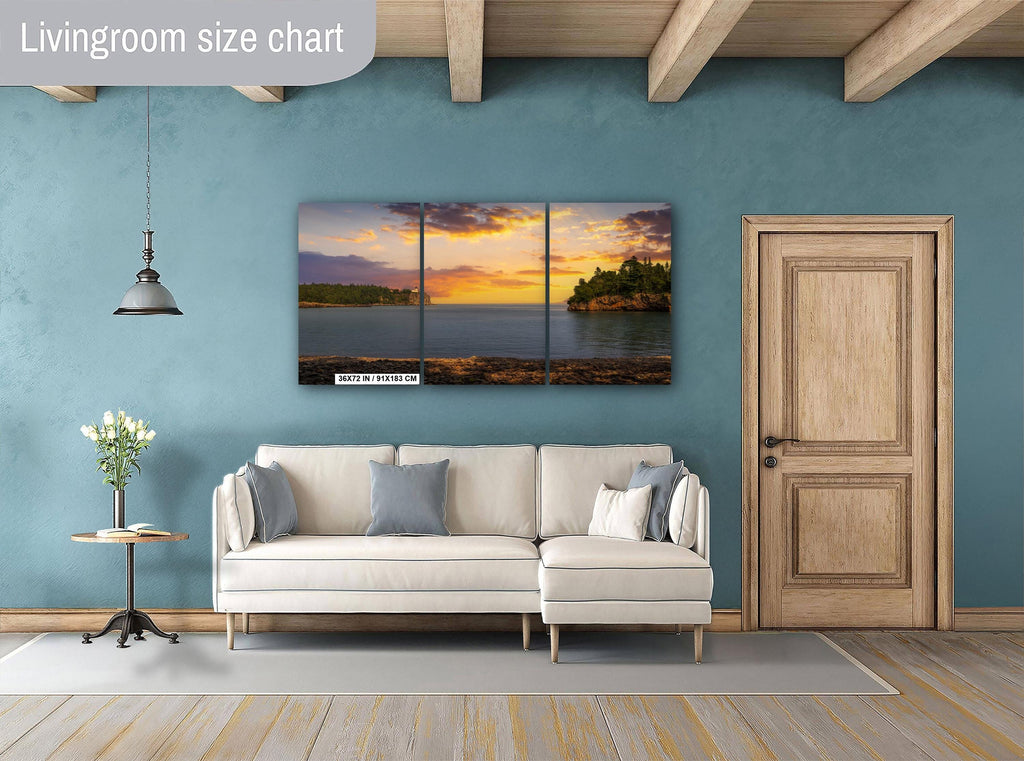 Living room with a sectional sofa, side table, and wall art depicting a sunset over water.