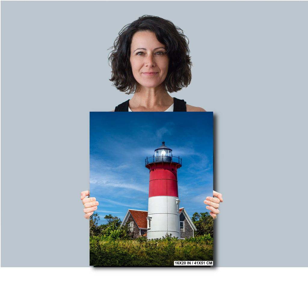 Woman holding a poster of Nauset Lighthouse against a blue sky.