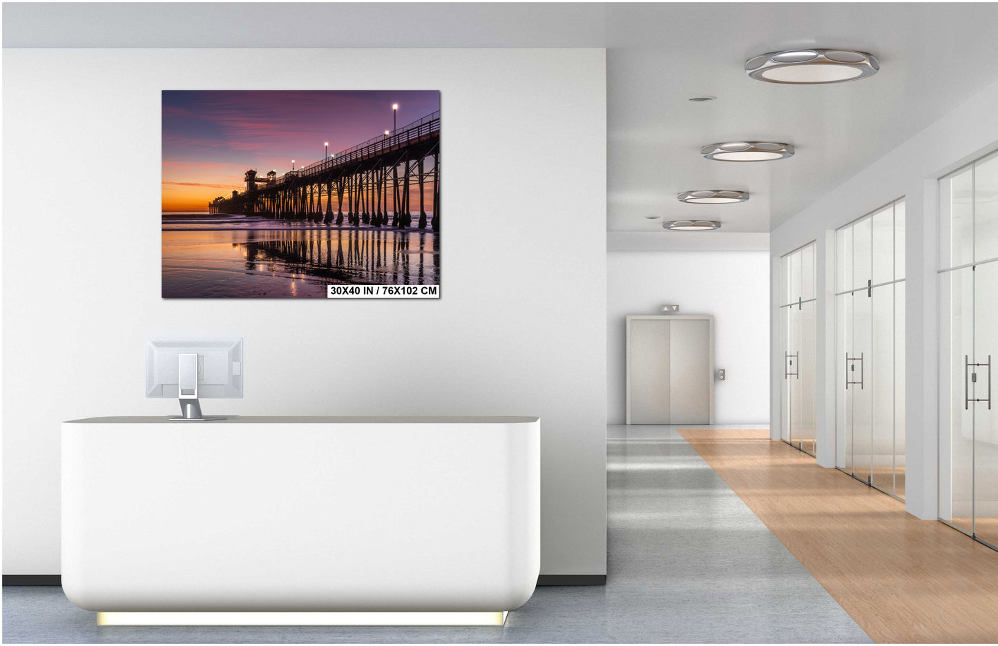 a modern office space with a white desk and a large wall-mounted painting depicting a pier at sunset.