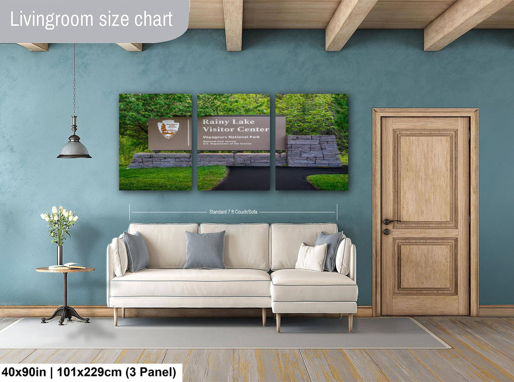 Living room with a sofa, side table, and wall art displaying a size chart.