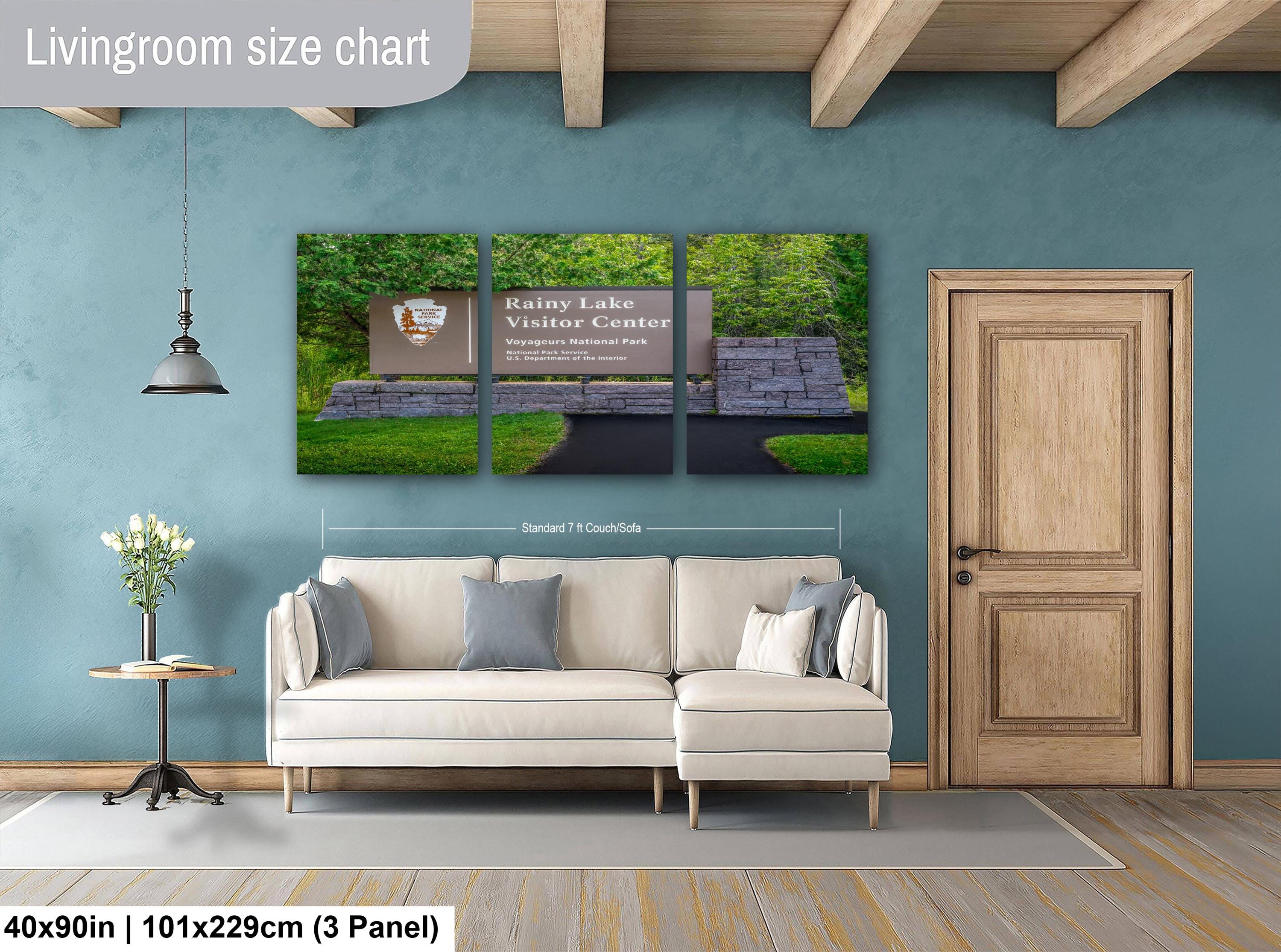 Living room with a sofa, side table, and wall art displaying a size chart.