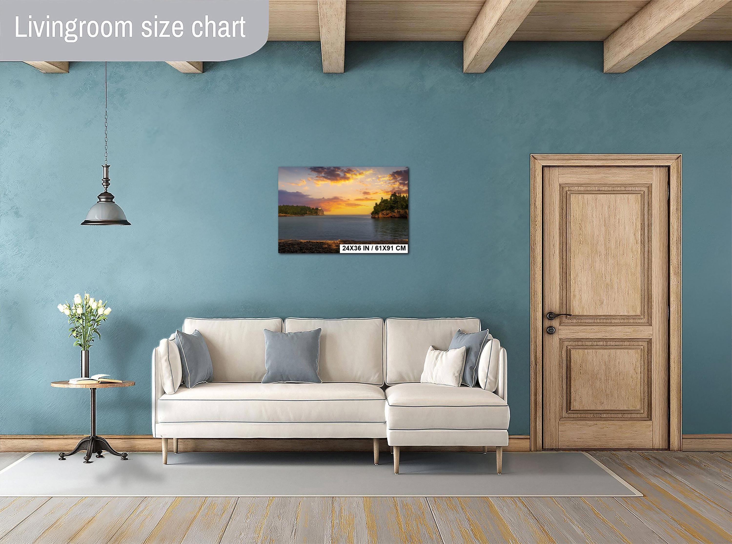 Living room with a sofa, side table, and wall art depicting a sunset over water.