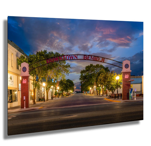 Twilight view of Downtown Bemidji archway with glowing lights and peaceful Main Street scene.