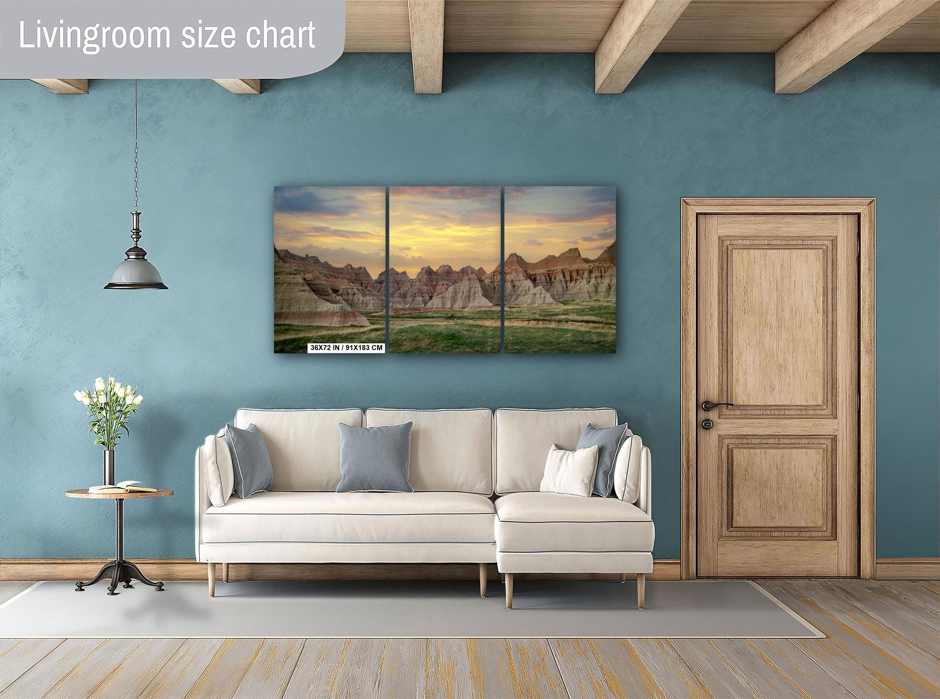 Living room with a sectional sofa, side table, and wall art depicting mountains.