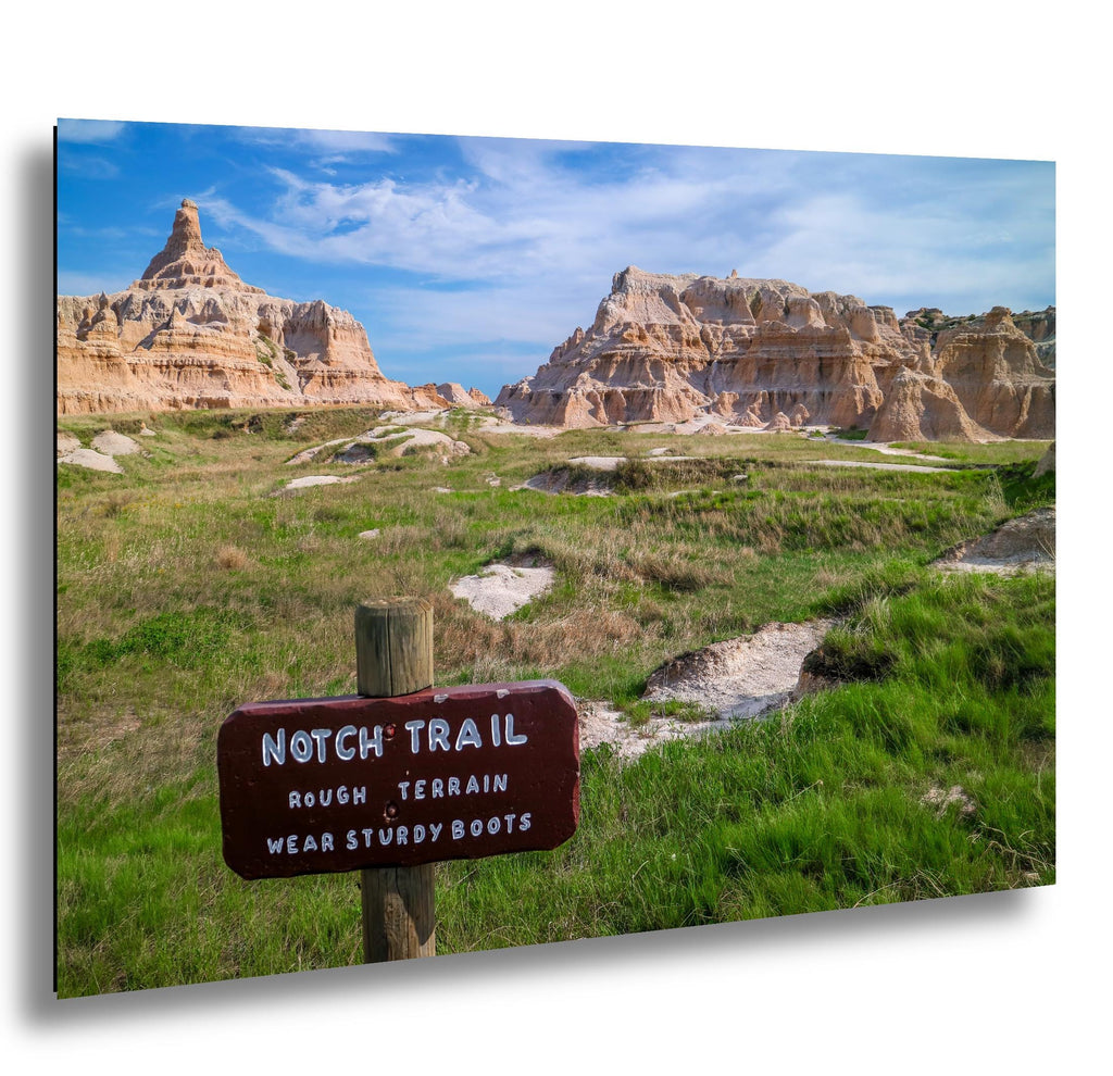 Scenic view of a rocky landscape with a 'Notch Trail' sign warning of rough terrain and stony boots.