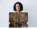 Woman holding a large photo print of Lake Martin Louisiana Cypress Swamp Trees