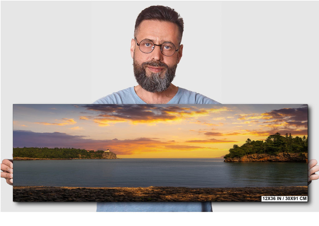 Man holding a panoramic landscape of a sunset over water