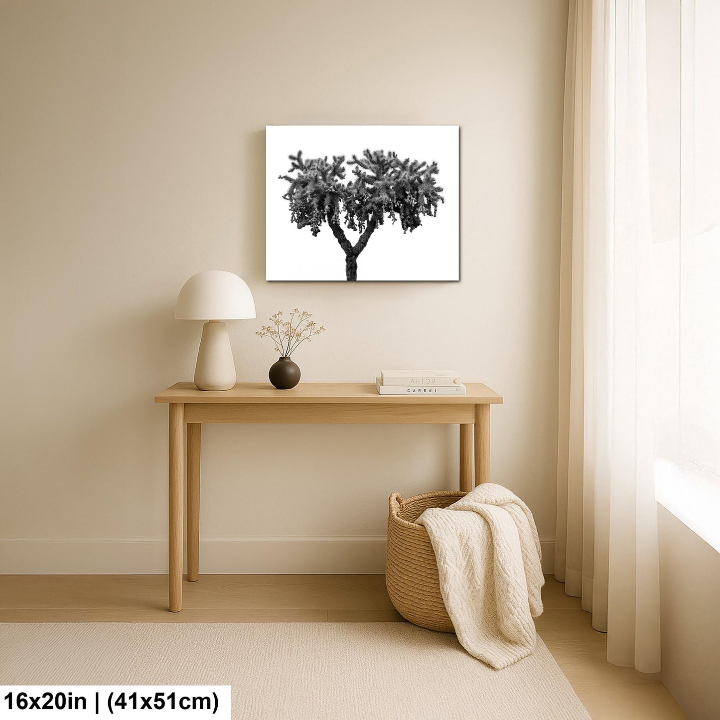 Room interior with a table, lamp, and decorative items against a beige wall with a framed picture of a tree.