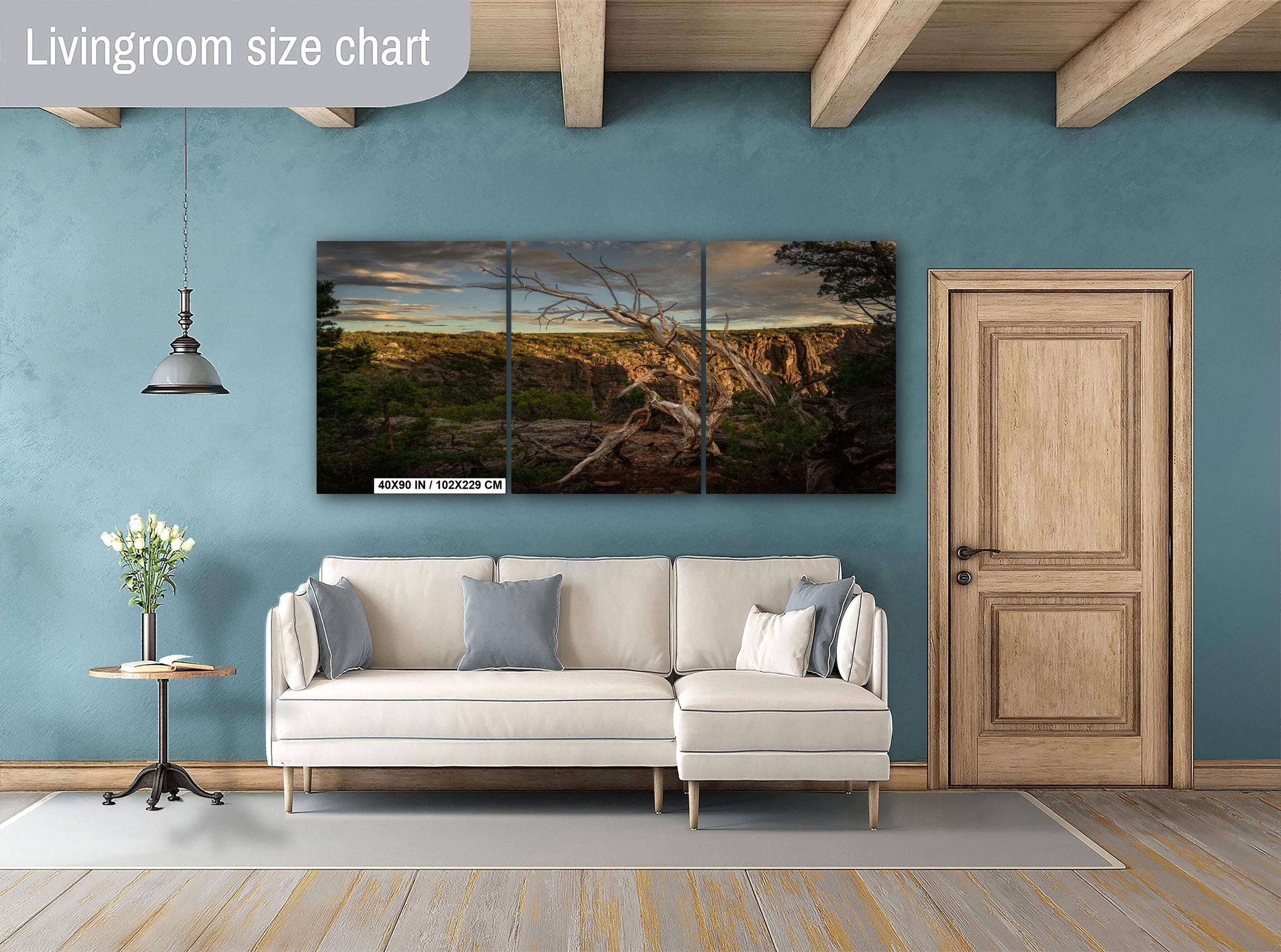 Living room with a sofa, side table, and wall art on a blue wall.