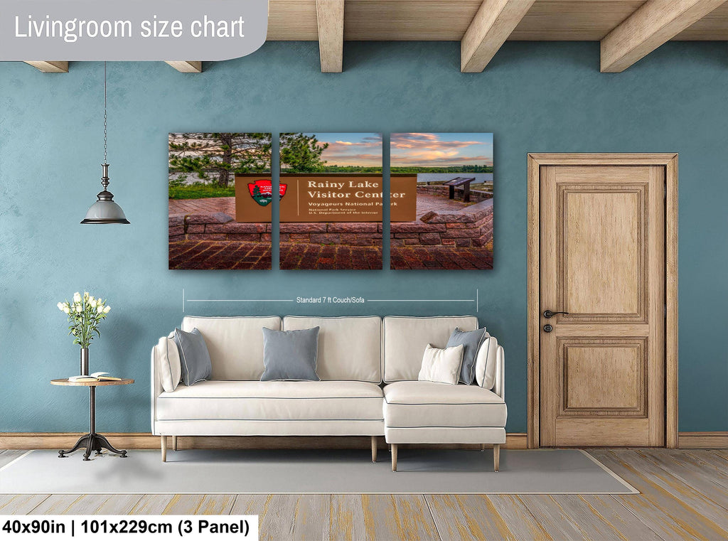 Living room with a sofa, side table, and wall art depicting Rainy Lake Visitor Center.