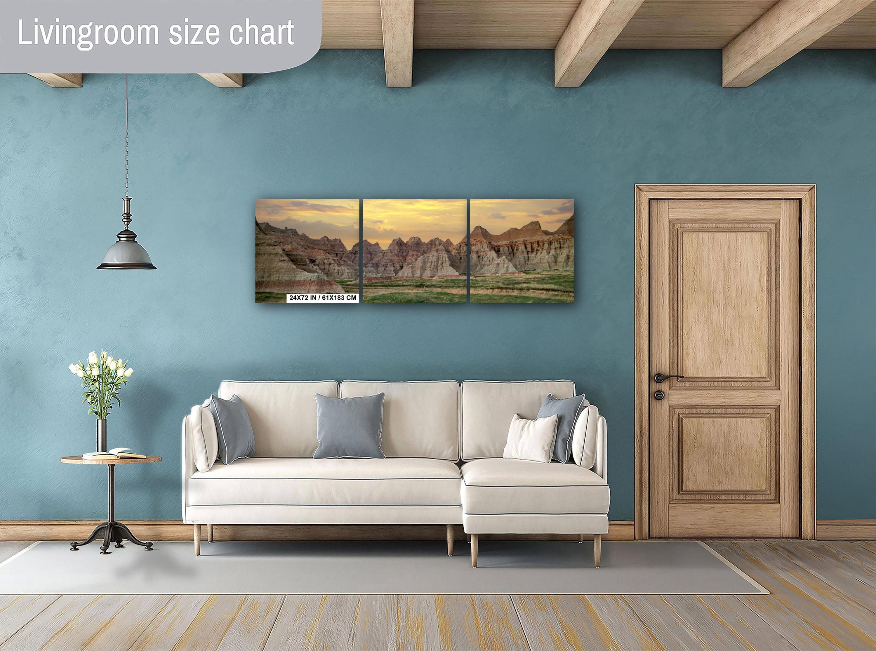 Living room with beige sofa, side table, and wall art of mountain landscape.
