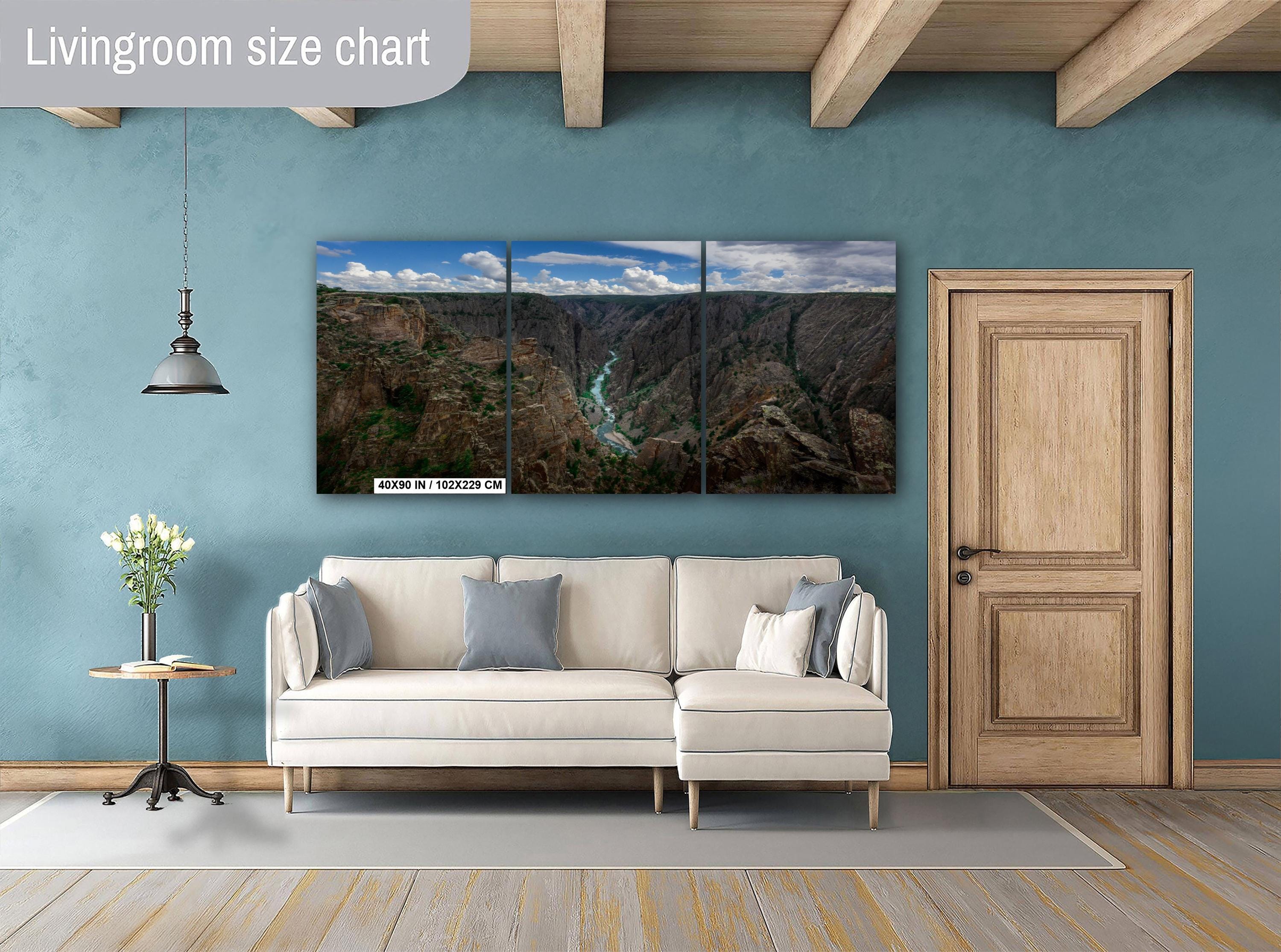Living room with a large wall-mounted photography displaying a nature scene, beige sofa, and wooden door.