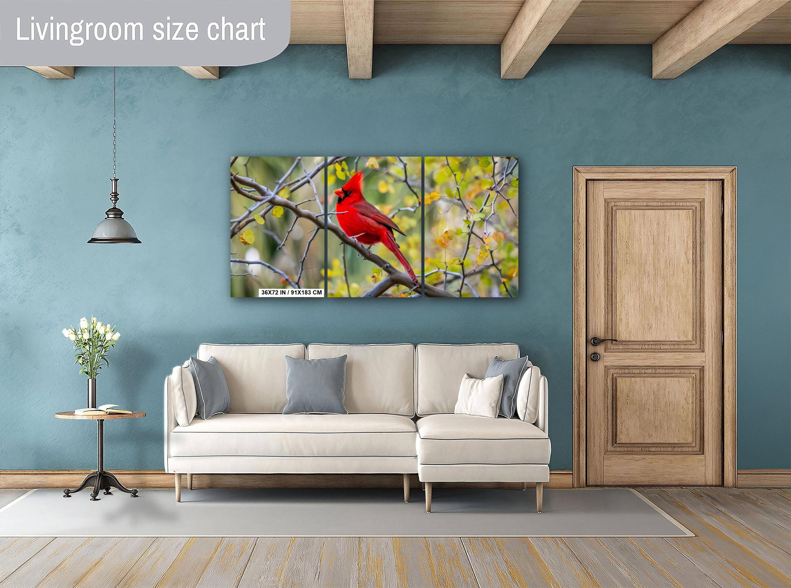 Living room with a triptych wall art of a red cardinal on a blue wall.