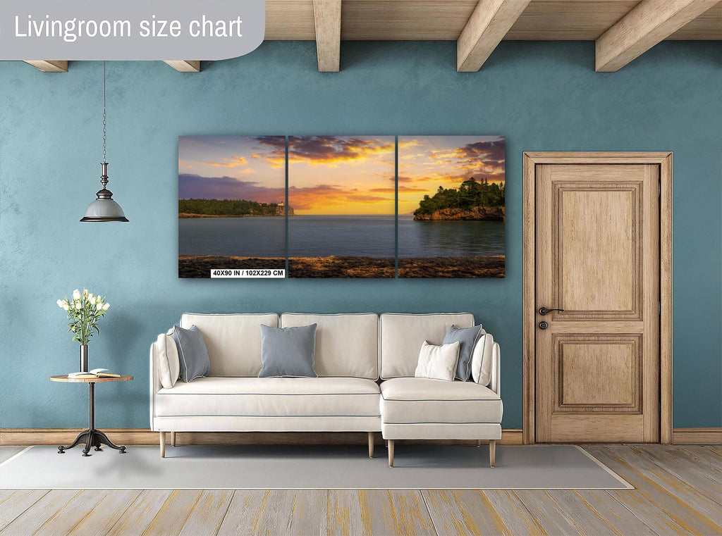 Living room with a sectional sofa, side table, and wall art depicting a sunset over water.