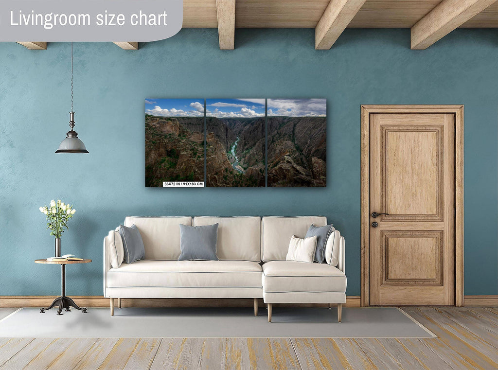 Living room with a large wall-mounted nature-themed triptych painting, beige sofa, and wooden door.