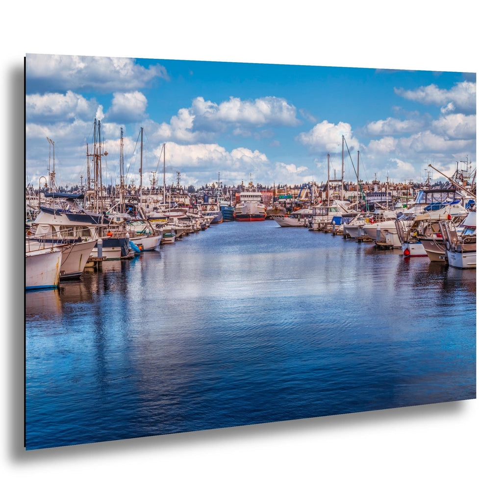 Seattle marina lined with boats, calm blue water and cotton clouds