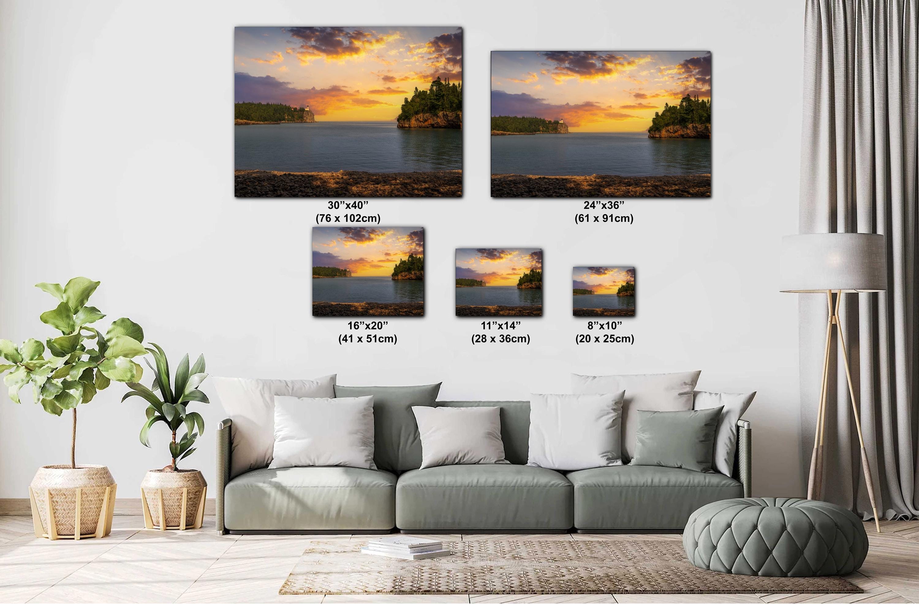 Living room with a sofa and decorative plants, featuring wall art of sunset over water scenes with measurements.