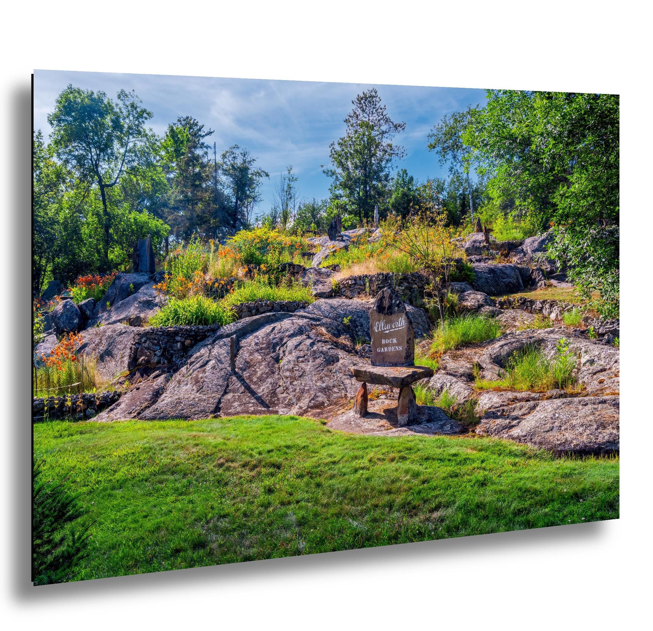Stone marker at Ellsworth Rock Gardens with granite outcrops and wildflowers.