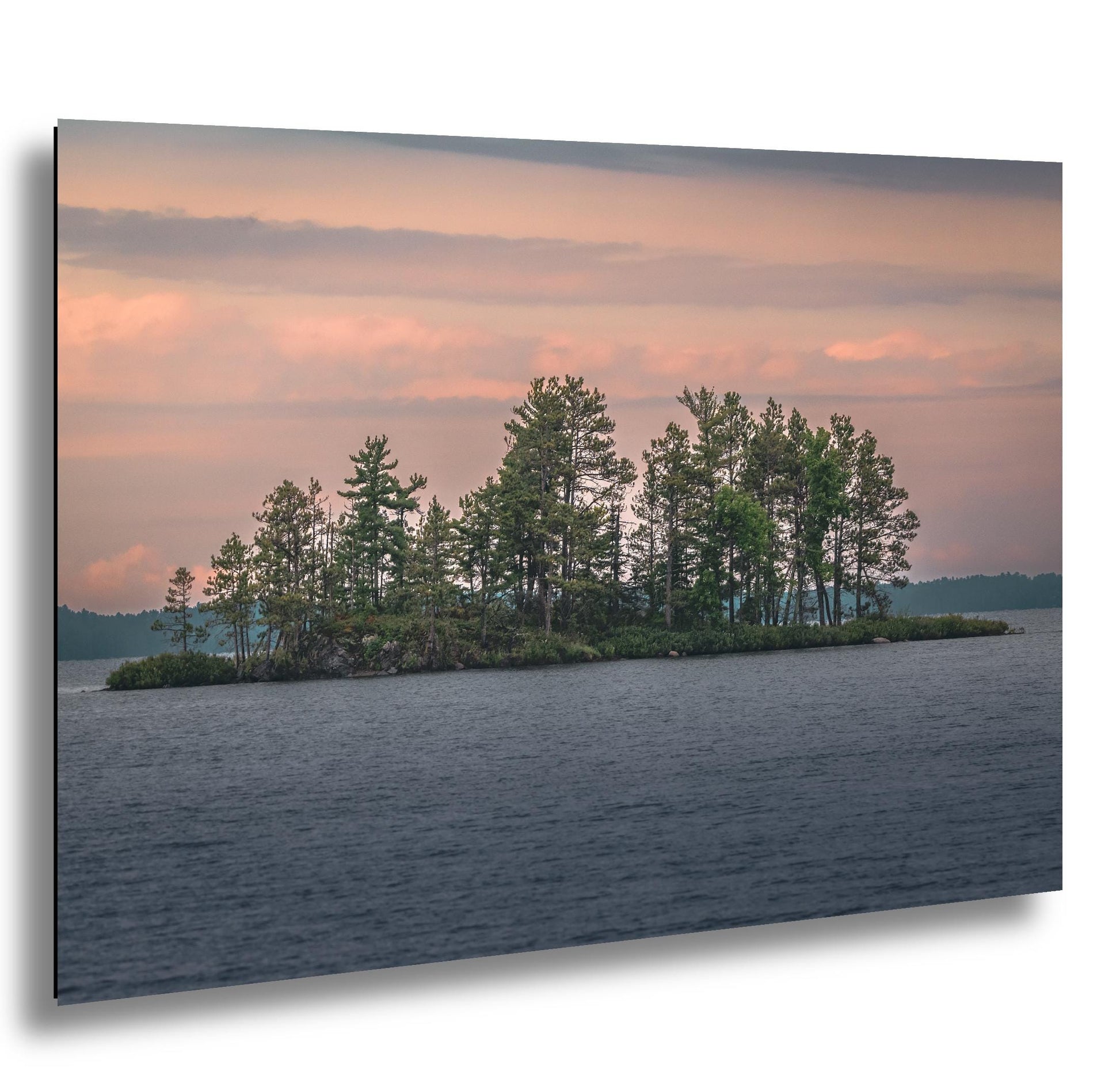 Pine Island at sunset in Voyageurs National Park, Minnesota, with lake water and pastel sky.