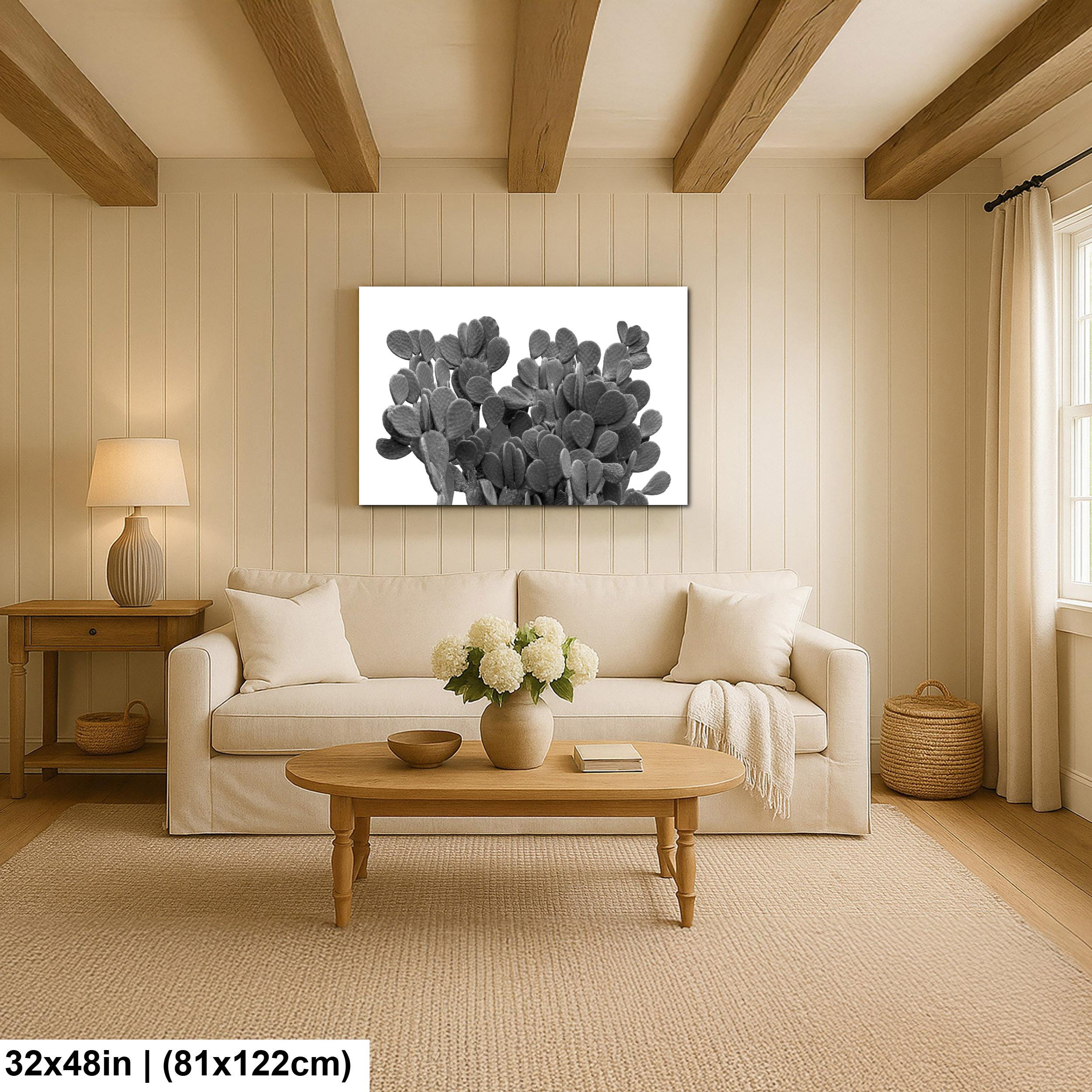 Living room with a white sofa, wooden coffee table, and cactus artwork on the wall.