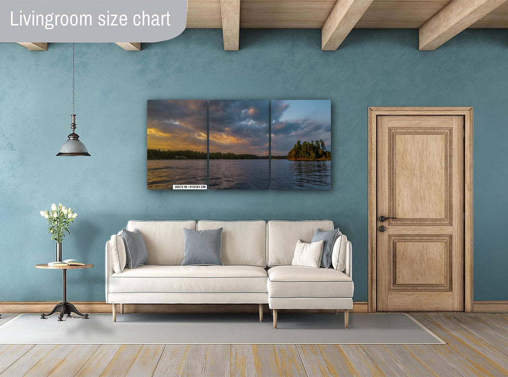 Living room with a sectional sofa, side table, and wall art depicting a sunset over water.