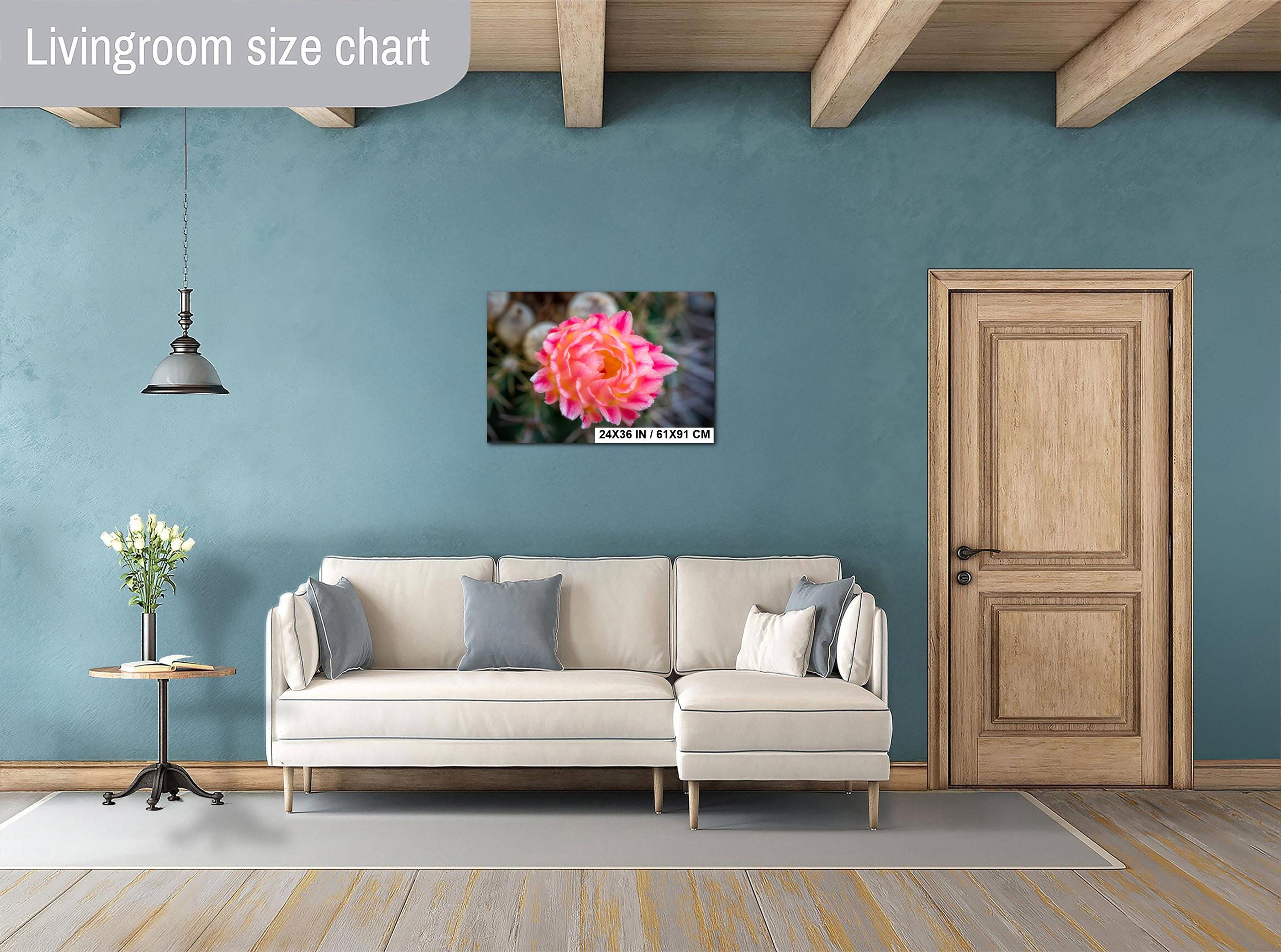 Living room with a beige sofa, pink cactus flower print, and wooden door.