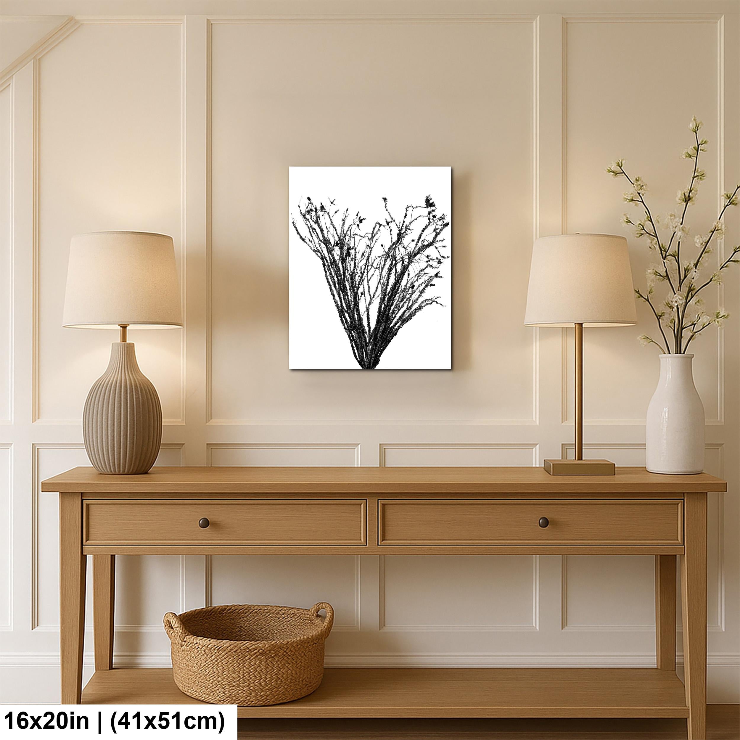 Wooden console table with lamps, a vase, and a basket against a wall with a printed wall art.
