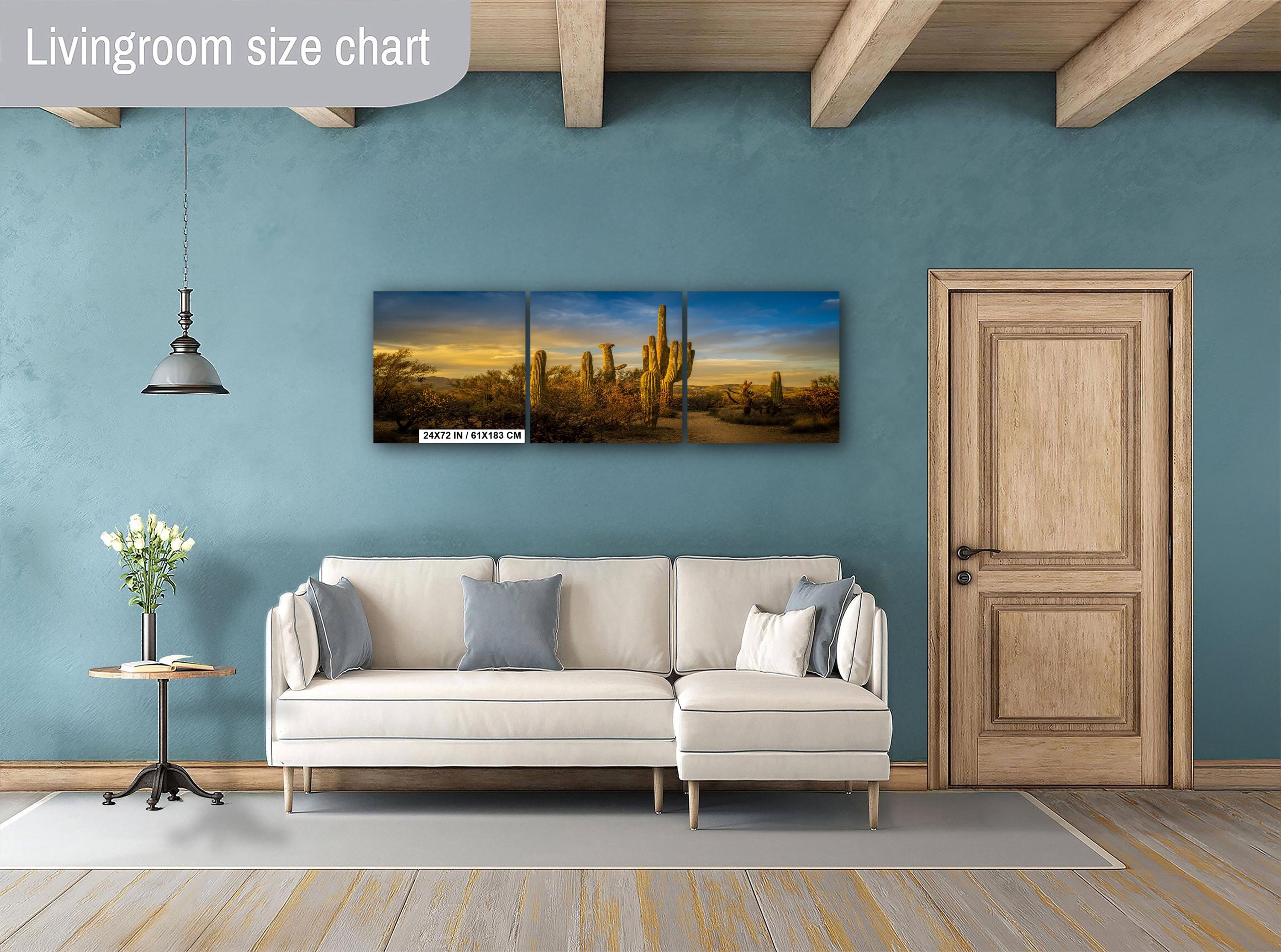 Living room with beige sectional sofa, side table, and wall art depicting a desert landscape.