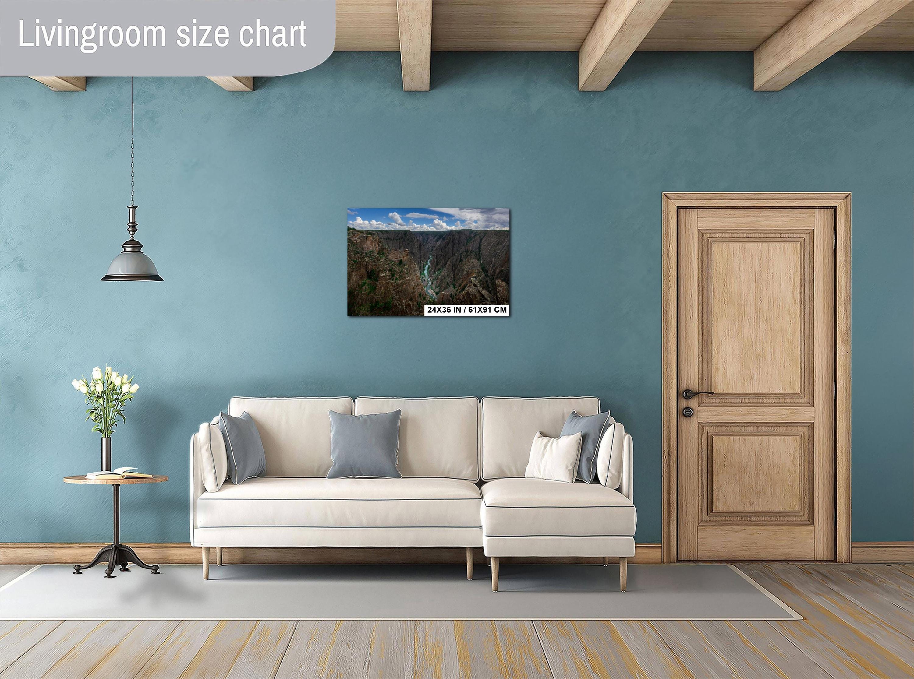 Living room with a beige sofa, side table, and wall art on a blue wall.