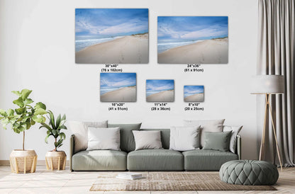 A living room with a green sofa featuring various sizes of beach photography canvas prints on the wall, ranging from 8"x10" to 30"x40".